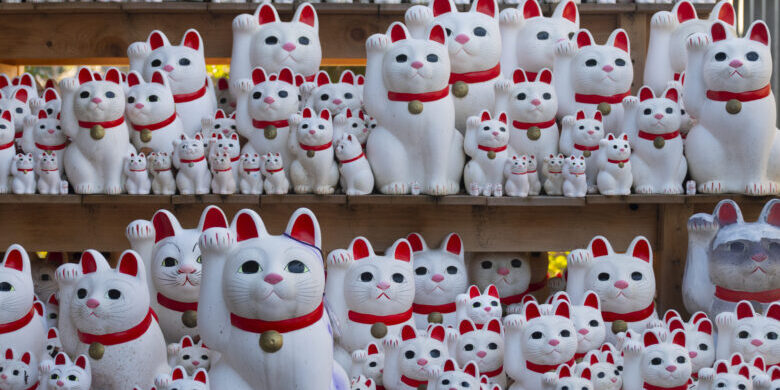 Lucky cat on shelf in Gotokuji temple Tokyo Maneki neko Japan culture